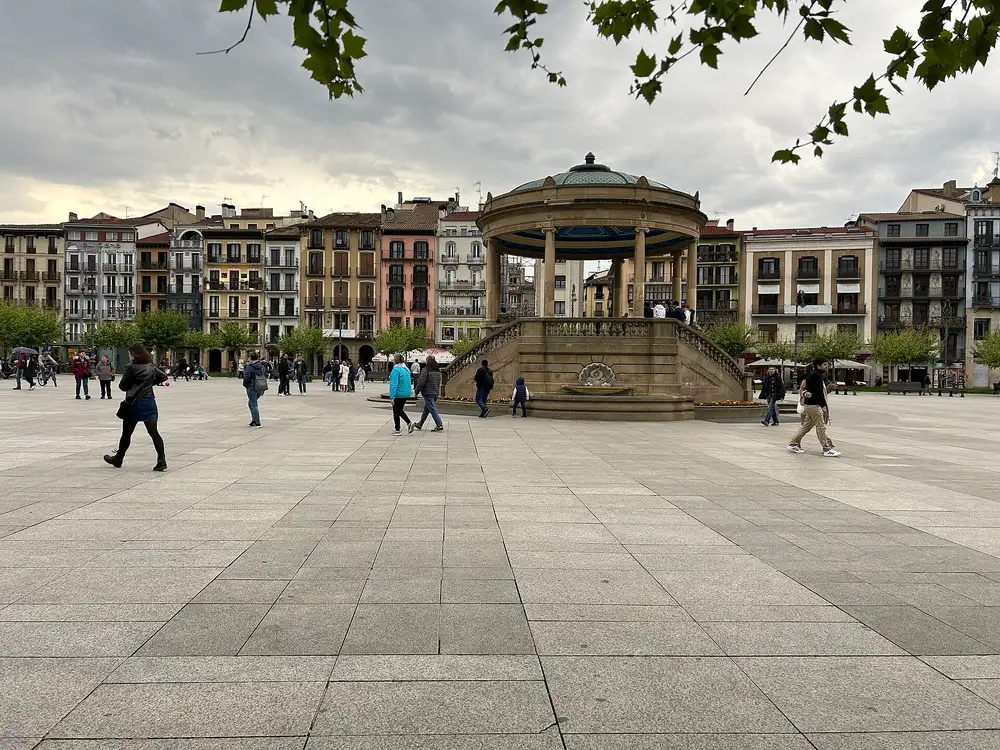 Plaza del Castillo de Pamplona, con su quiosco en el centro, el suelo de losas y una fila de edificios de varias plantas al fondo
